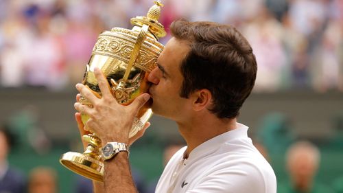 Roger Federer kisses his eighth Wimbledon trophy. (AAP)