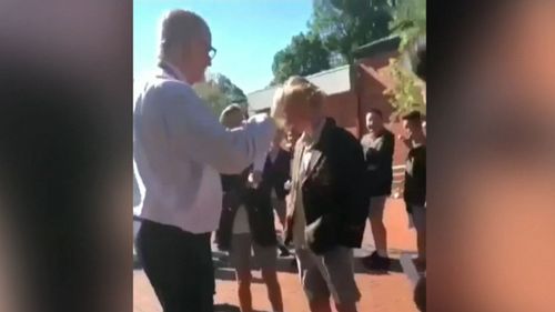 Mr Brown was filmed trimming a student's hair on school photo day. (The Age)