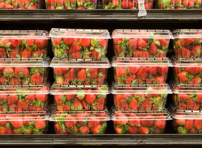 Strawberries in containers on supermarket shelf