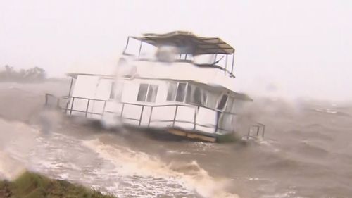 A houseboat washed ashore and stranded in waters off Queensland.
