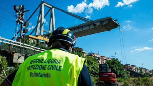 A worker inspects the the area around the collapsed Morandi highway bridge, in Genoa, northern Italy.