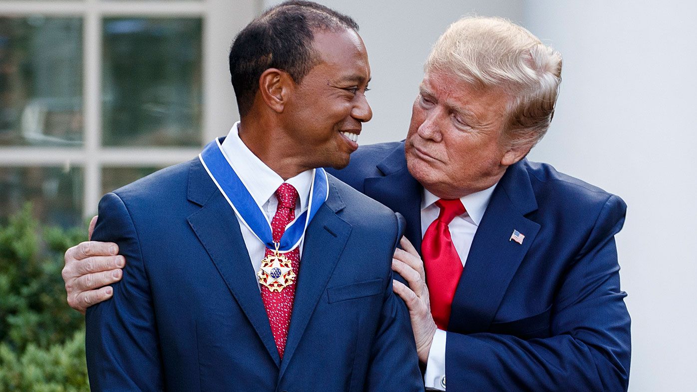 Woods receives the medal from Trump