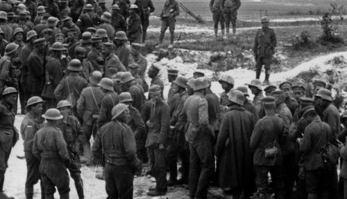 German prisoners with their Australian captors after the battle. (Photo: AWM).