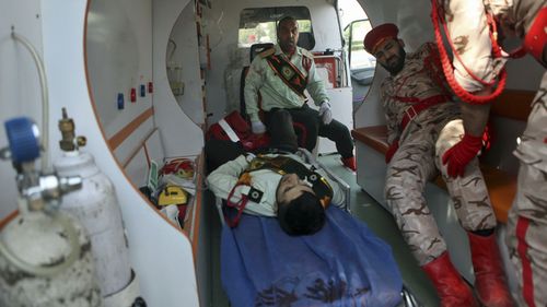 Wounded military personnel are carried into an ambulance after a shooting during a military parade marking the 38th anniversary of Iraq's 1980 invasion of Iran, in the southwestern city of Ahvaz, Iran. (AP)