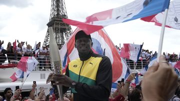 Olympics legend Usain Bolt with the torch as Paris celebrated one year until the 2024 Games.