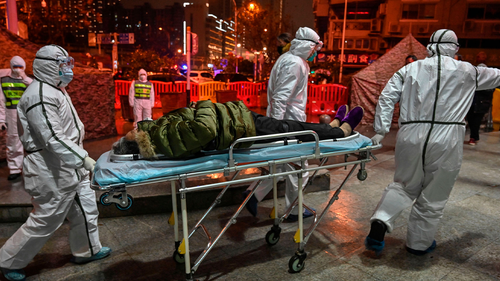 Medical staff members wearing protective clothing to help stop the spread of a deadly virus which began in the city, arrive with a patient at the Wuhan Red Cross Hospital in Wuhan on January 25, 2020. - The Chinese army deployed medical specialists on January 25 to the epicentre of a spiralling viral outbreak that has killed 41 people and spread around the world, as millions spent their normally festive Lunar New Year holiday under lockdown. (Photo by Hector RETAMAL / AFP) (Photo by HE