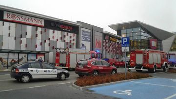 Police and firefighters' cars and trucks stand in front of the VIVO! shopping mall where a 27-year-old man attacked people with a knife, killing one person and injuring several others in Stalowa Wola, southeastern Poland. (AP)