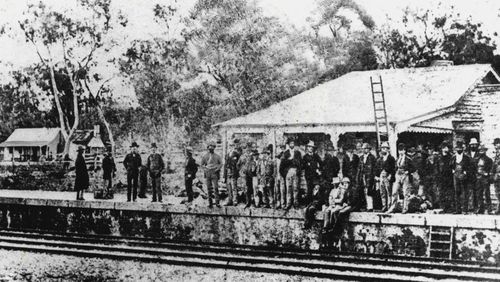 When police besieged the Ned Kelly Gang in the Glenrowan Hotel (left background in picture) hundreds of spectators gathered nearby, some even using a ladder to get a better view from the roof of the railway station. This unusual picture is from 100 Australian Bushrangers, 1789-1901 (Rigby, $14.95), by Allan M. Nixon. He says that the total number of bushrangers in Australia's past probably ran into hundreds; many of them received little publicity. March 13, 1988.