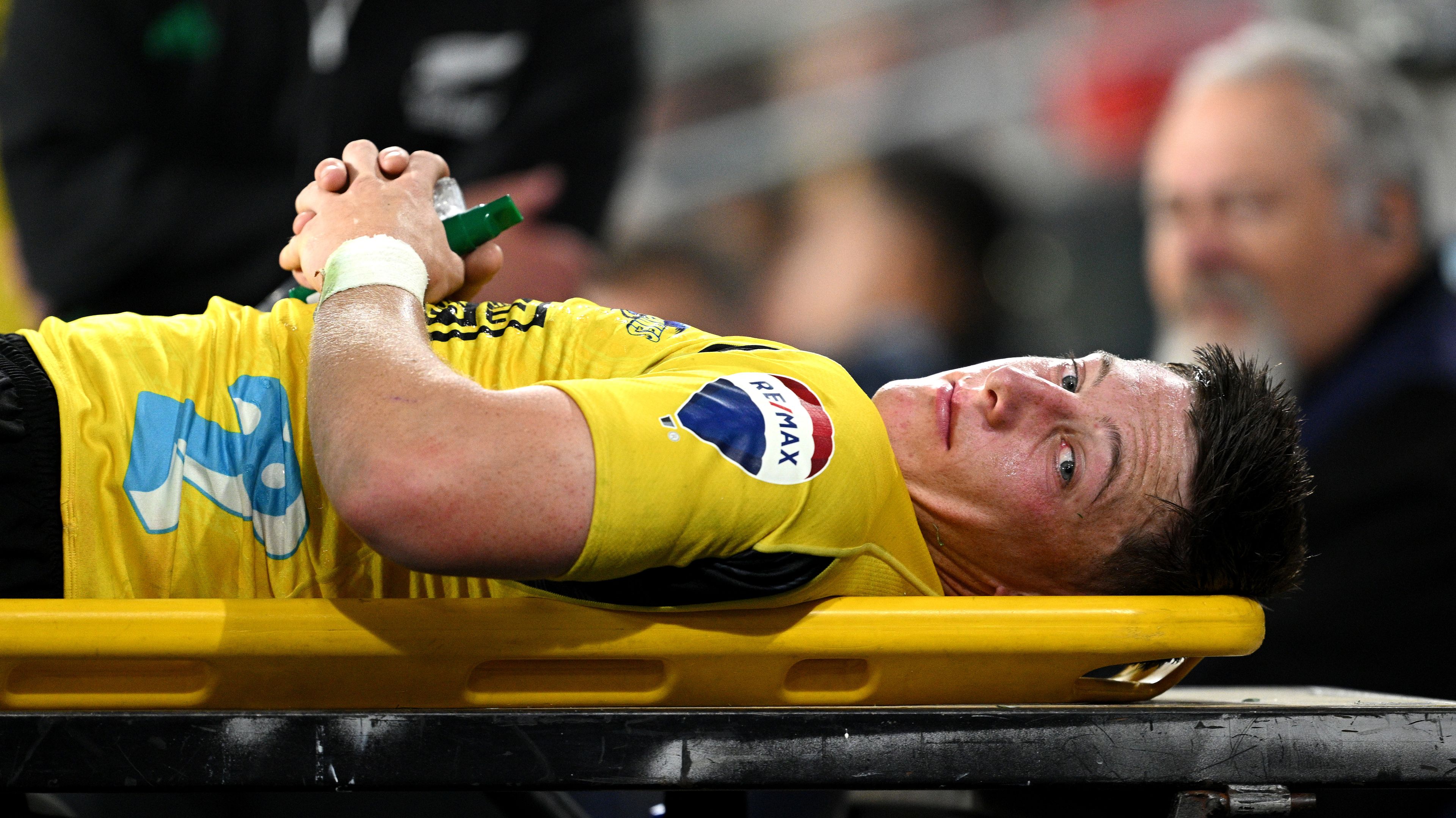 Cam Roigard of the Hurricanes leaves the field of play after suffering an injury.