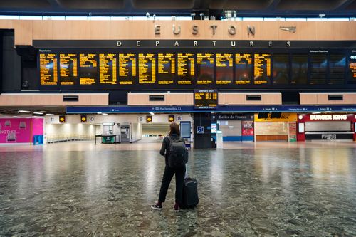 A passenger at Euston station in London looks at the departures board on the first day of a rail strike on Tuesday June 21, 2022. 
