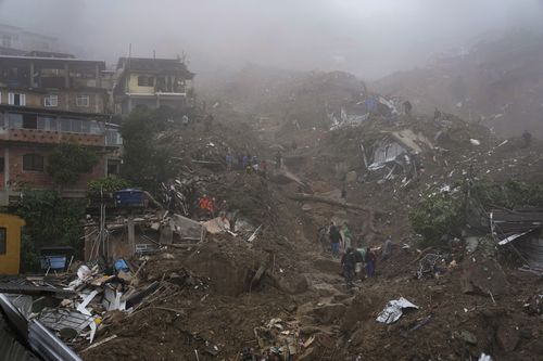 Rescue workers and residents look for victims  in an area affected by landslides in Petropolis, Brazil, Wednesday, Feb. 16, 2022. 