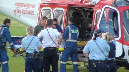 A two-year-old girl is loaded into the Ambulance Helicopter at Hazlett Oval, Macquarie Fields, after a near-drowning incident at Long Point. (9NEWS)