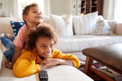 Two kids watching tv. 