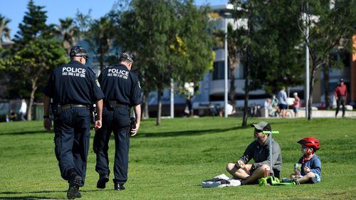 NSW Police ask people to move on while patrolling during the Easter Long Weekend at Bondi Beach in Sydney, Sunday, April 12, 2020. (AAP Image/Joel Carrett) NO ARCHIVING