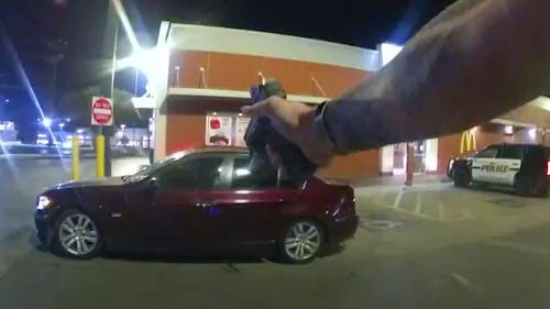 In this image taken from Oct. 2, 2022 police body camera video and released by San Antonio Police Department, Erik Cantu drives away as San Antonio Police officer James Brennand shoots his pistol at the car in a fast food restaurant parking lot in San Antonio, Texas. 