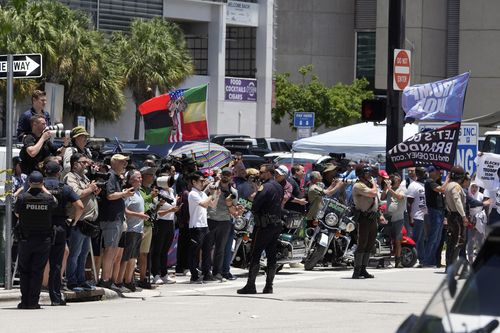 People watch as they motorcade carrying former President Donald Trump arrives at the Wilkie D. Ferguson Jr. US Courthouse, Tuesday, June 13, 2023, in Miami