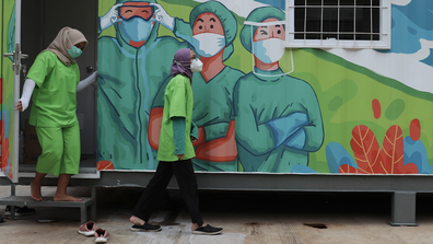 Health worker walks outside a mobile laboratory before analyze samples collected during mass coronavirus tests in Jakarta, Indonesia, Thursday, June 18, 2020.(AP Photo/Achmad Ibrahim)