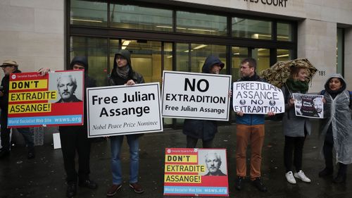 Supporters of WikiLeaks founder Julian Assange protest in front of Westminster Magistrates Court in London, Friday, Dec. 20, 2019. Assange is expected to appear in person before Westminster Magistrates in a private hearing related to a Spanish criminal case about alleged surveillance at the Ecuador embassy.