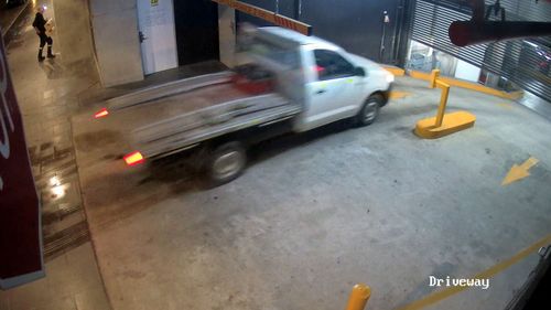 The thief drives a stolen ute under the closing gates of a Sydney apartment block.