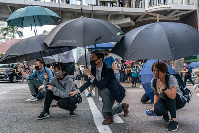 November 13: Pro-democracy protesters hold umbrellas as they walk on a street during a standoff with police.