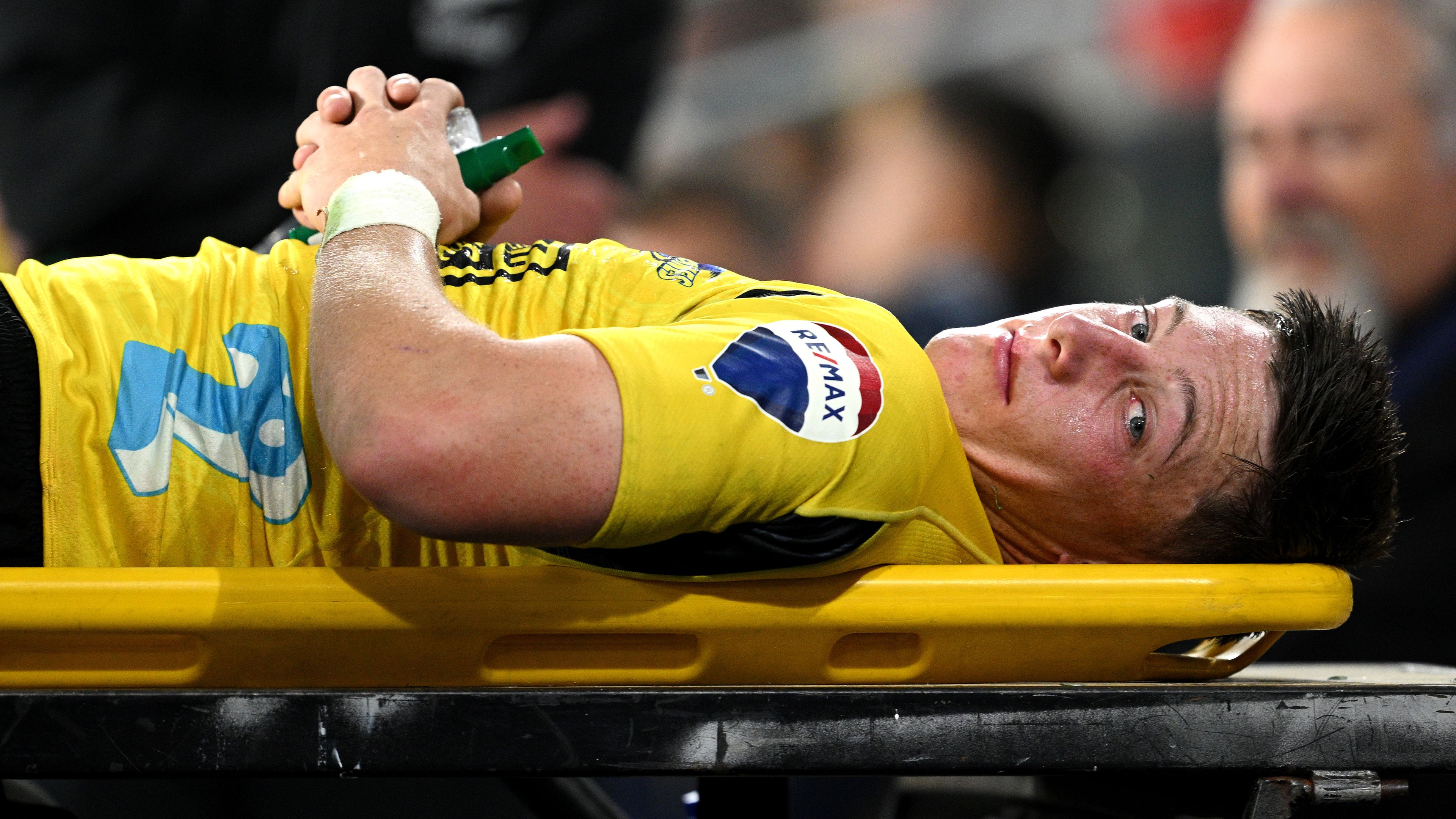 Cam Roigard of the Hurricanes leaves the field of play after suffering an injury.