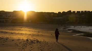 A runner at sunrise on Bondi Beach in Sydney.