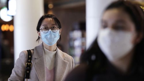 Travelers at Seattle-Tacoma International Airport wear masks Tuesday, March 3, 2020.