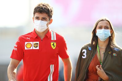 MONZA, ITALY - SEPTEMBER 11: Charles Leclerc of Monaco and Ferrari walks in the Paddock with his girlfriend Charlotte Sine before practice ahead of the F1 Grand Prix of Italy at Autodromo di Monza on September 11, 2021 in Monza, Italy. (Photo by Bryn Lennon/Getty Images)
