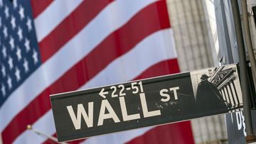 Monday, Sept. 21, 2020, file photo, a Wall Street street sign is framed by a giant American flag hanging on the New York Stock Exchange in New York