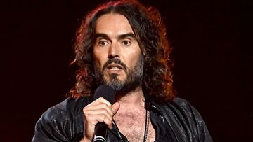 Russell Brand speaks onstage.