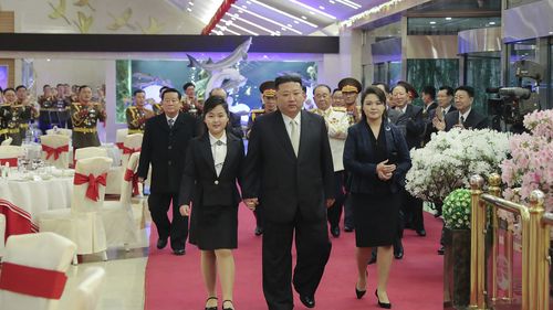 North Korean leader Kim Jong Un, center, with his wife Ri Sol Ju, right, and his daughter attend a feast to mark the 75th founding anniversary of the Korean People's Army at an unspecified place in North Korea on Tuesday.