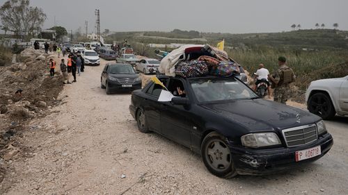 Displaced people cross a destroyed bridge while returning to their villages on the second day of a ceasefire between Hezbollah and Israel in Qasmiyeh, near Tyre city, southern Lebanon.