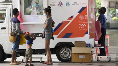 Health workers collect nasal swabs from locals for coronavirus testing at a mobile facility in Bangkok, Thailand.