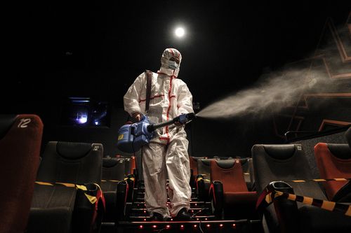 An employee in protective clothing disinfects a cinema at Wuhan, the epicentre of the COVID-19 pandemic.