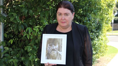 Julie Ann Stewart carries a photo of her late brother Mark Russell, who was murdered nearly five years ago. 