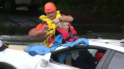 An 87-year-old woman was rescued from her 4WD after it became submerged in rising floodwaters off a causeway near Taree, NSW yesterday (Supplied).