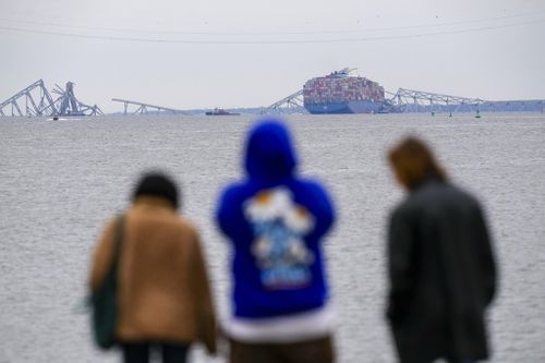 People view from Fort McHenry a container ship as it rests against the wreckage of the Francis Scott Key Bridge, Thursday, March 28, 2024, in Baltimore, Md.