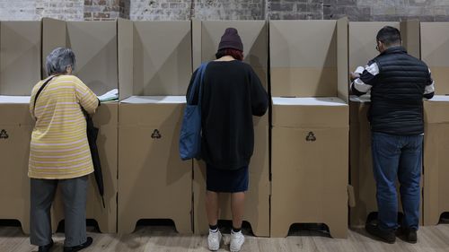 People cast their ballots during early voting for the seat of Wentworth at Oxford Street Mall on May 20, 2022 in Sydney, Australia. Independent Allegra Spender is standing for the seat of Wentworth against Liberal incumbent Dave Sharma. The Australian federal election will be held on Saturday 21 May 2022. (Photo by Brook Mitchell/Getty Images)