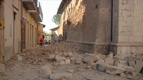 In this image made from video, bricks fallen from a damaged building block a street in Norcia, Italy. (AAP)