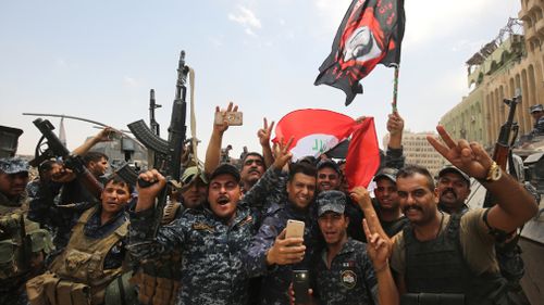 Members of the Iraqi federal police dance and wave their country's national flag as their part of the battle for the Old City of Mosul is declared accomplished. (AFP)