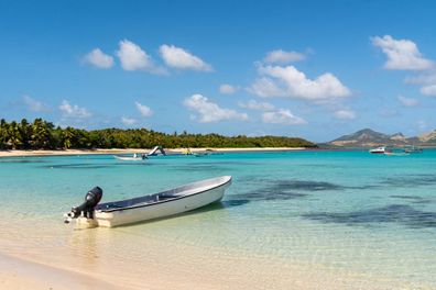Boat on a white sand beach in the Blue lagoon island in the Yasawa islands group in Fiji in the South Pacific