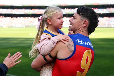 MELBOURNE, AUSTRALIA - APRIL 19: Lachie Neale of the Lions takes to the field with his daughter, Piper, during his 300th match during the sixth round AFL match between Melbourne Demons and Brisbane Lions at the Melbourne Cricket Ground, on April 19, 2026, in Melbourne, Australia. (Photo by Daniel Pockett/AFL Photos/via Getty Images)