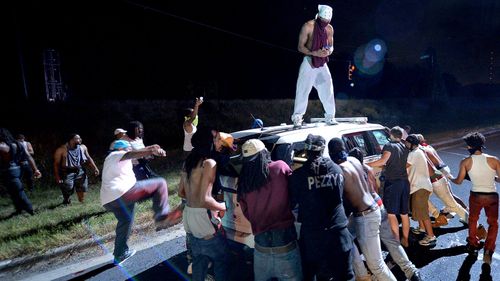 Protester surround a car in Charlotte. (AAP)