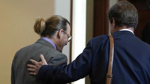 Attorney Ben Chew leaves with his client, actor Johnny Depp at the Fairfax County Circuit Court in Fairfax, Va.