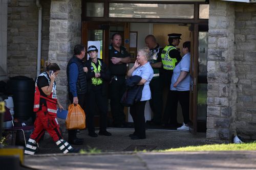 Staff and emergency services stand outside the Gainsborough care home after an incident on October 23, 2024 in Swanage, England. 