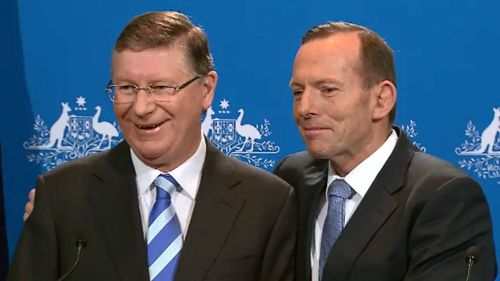 Denis Napthine and Prime Minister Abbott awkwardly embraced at a joint press conference in Melbourne. (9NEWS)