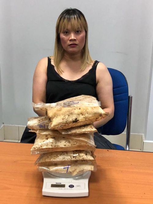 Ve Hi Tran pictured with the 1814 grams of heroin allegedly found in her luggage in Cambodia. (Image: Cambodia General Department of Immigration/Facebook)