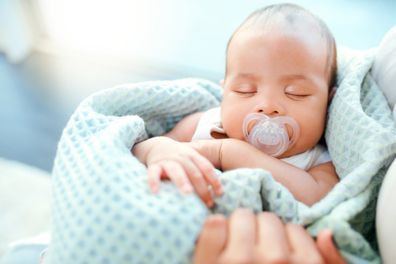 Baby boy sleeping in mum arms