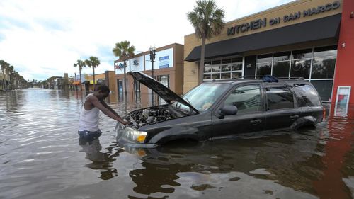 Florida resident John Duke tries to figure out how to salvage his flooded vehicle in the wake Hurricane Irma. (AAP)