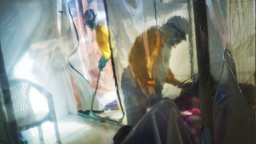 Health workers wearing protective suits tend to treat an Ebola victim in an isolation tent in Beni, Democratic Republic of Congo, on Saturday, July 13, 2019. (AP Photo/Jerome Delay, File)